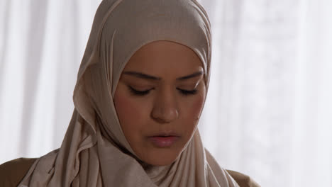Nahaufnahme-Einer-Muslimischen-Frau-Mit-Hijab,-Die-Zu-Hause-Steht-Und-Betet